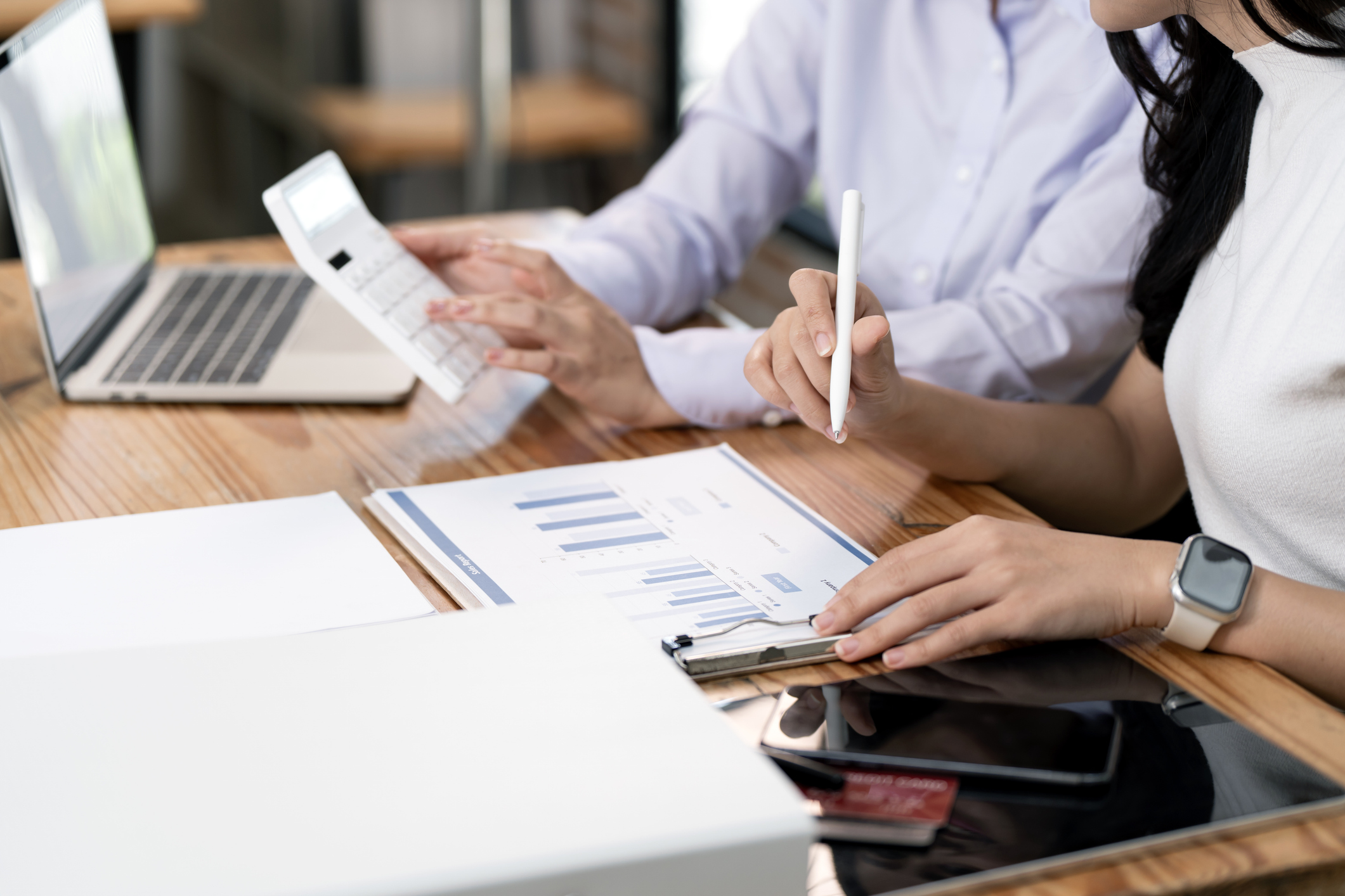 Business Women workign with graphs and a calculator
